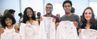 Five students from the Class of 2021 holding their white coats.